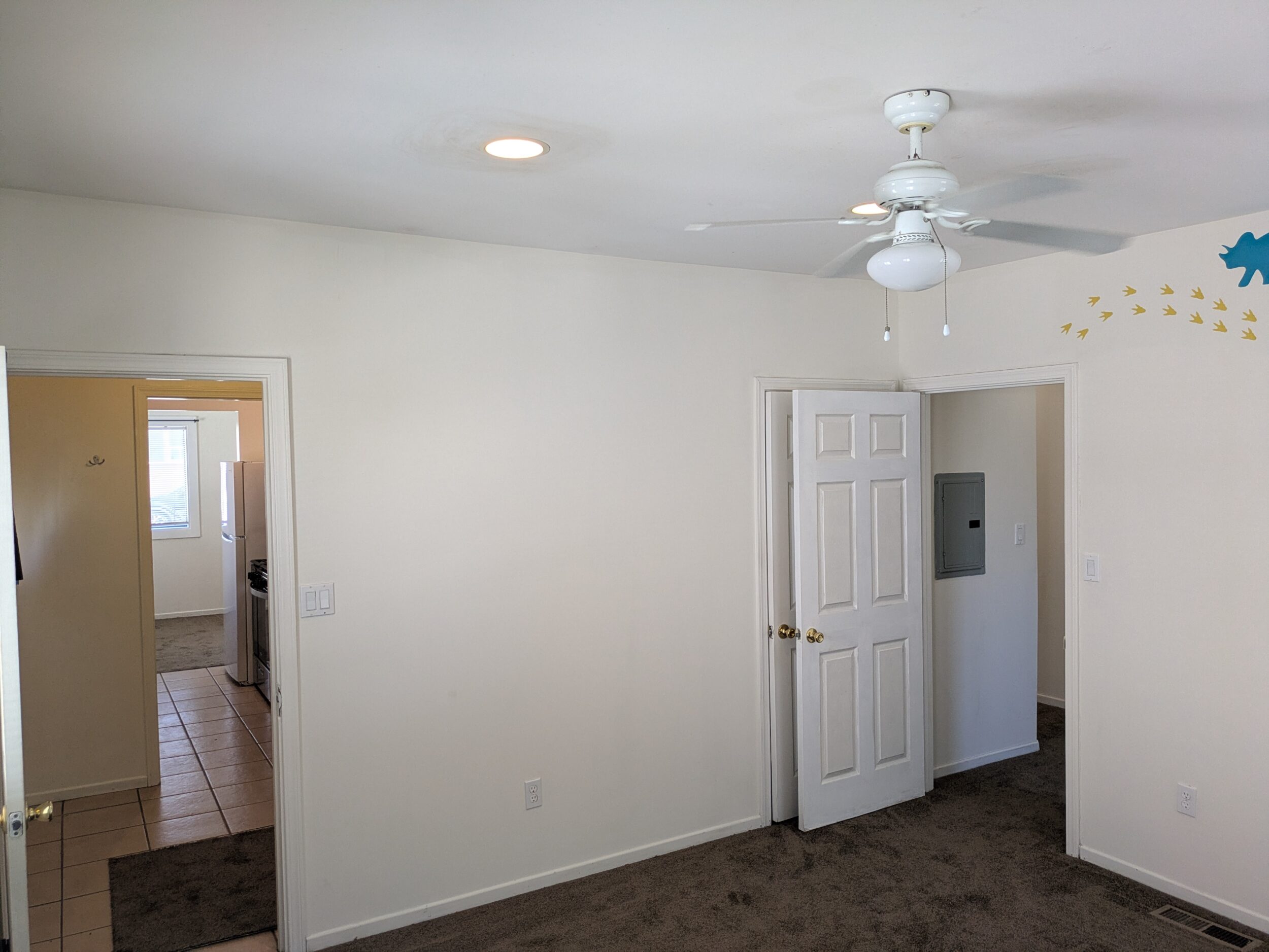 Bedroom. Opening to utility room/back door on the left, closet, and hallway to bath/livingroom on the right